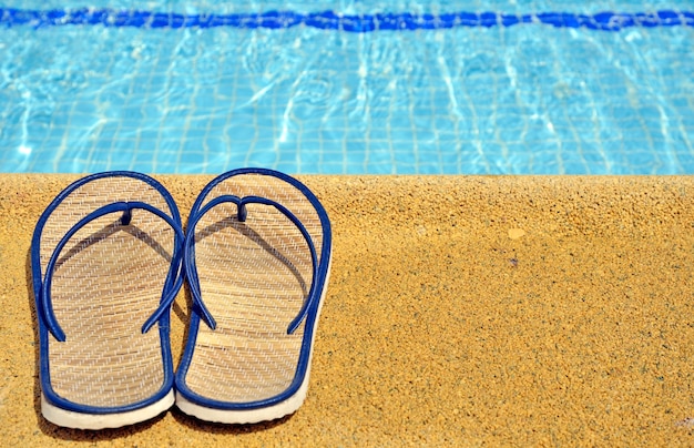 Sandálias femininas nos pés da piscina