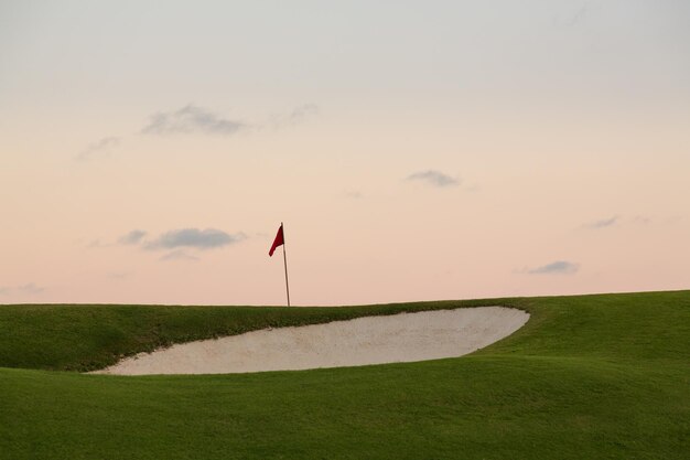 Sandbunker vor Golfgrün und Fahne