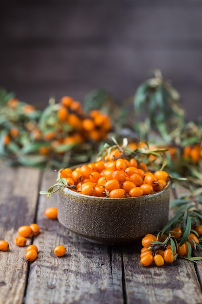 Sanddornbeeren in Schüssel auf Holzuntergrund