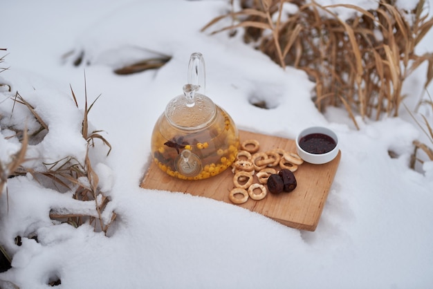 Sanddorntee im Schnee mit Marmelade und Trockenfrüchten im Herbst oder Winter öfter trinken