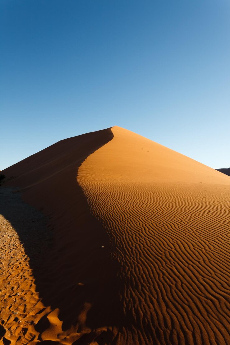 Foto sanddünen in der wüste gegen einen klaren blauen himmel
