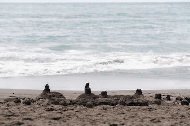 Sandfiguren am schwarzen Sandstrand von Los Gigantes auf Teneriffa, Kanarische Inseln, Spanien