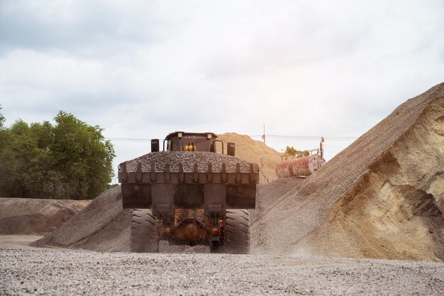 Sandlader schaufeln Steine in Muldenkipper