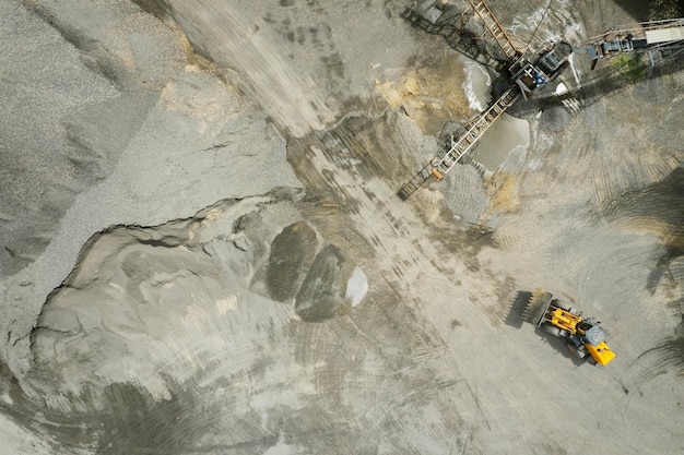 Sandlader schaufeln Steine in Muldenkipper