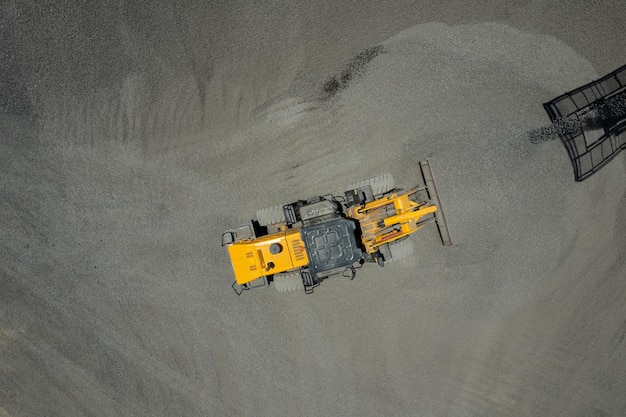 Sandlader schaufeln Steine in Muldenkipper