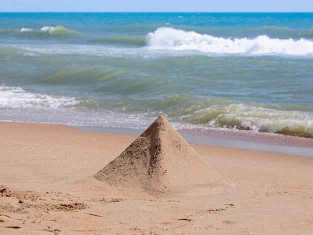 Sandpyramide auf dem Hintergrund des Meeres.