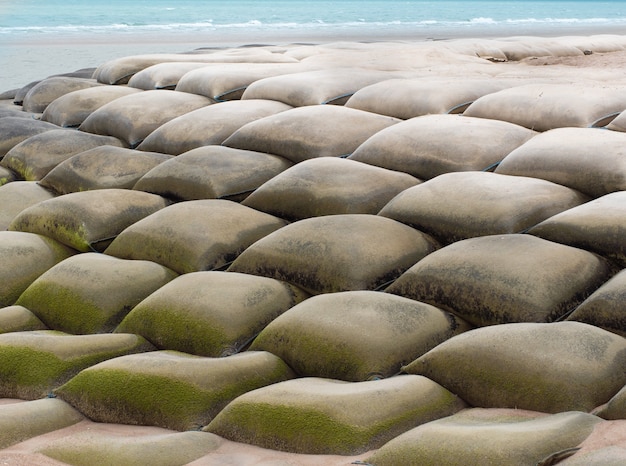 Sandsäcke oder sandbagger installiert zum schutz vor dem einsturz des strandes