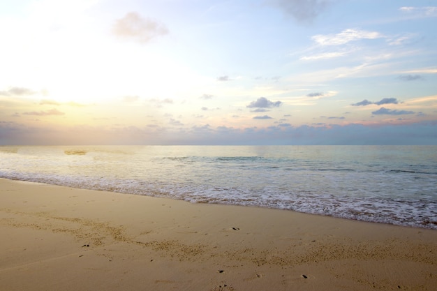 Sandstrand mit dem blauen Ozean und Sonnenunterganghimmel