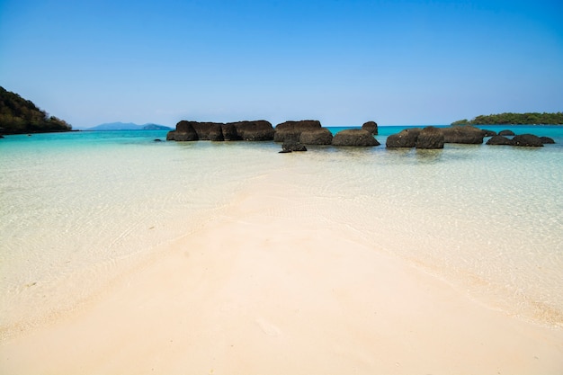 Foto sandstrand mit klarem meerwasser und blauem himmel
