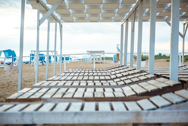 Sandstrand mit Liegestühlen und einem Holzdach in einem tropischen Resort an der Meeresküste Quarantäne