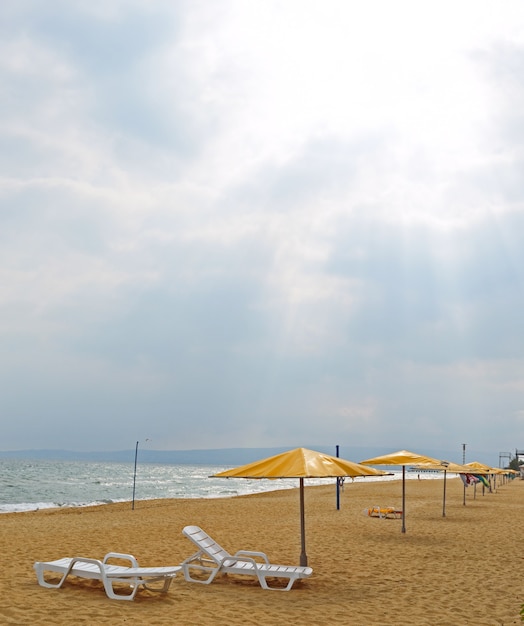 Sandstrand mit Sonnenschirmen, Liegestühlen. ohne Menschen