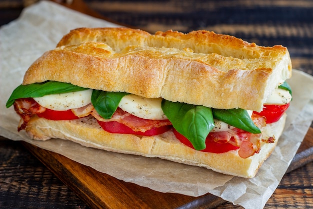 Sanduíche caprese com tomate, mussarela, manjericão e bacon. alimentação saudável. cozinha italiana.