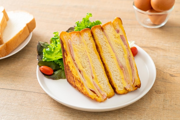 sanduíche caseiro de queijo e presunto com salada em prato branco