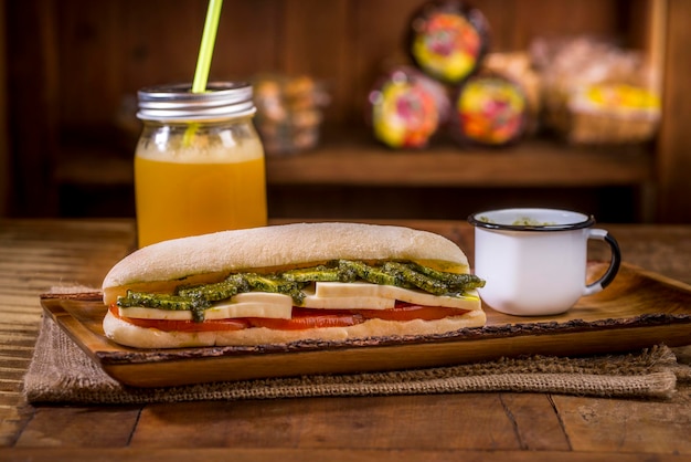 Foto sanduíche ciabatta com queijo, molho de tomate pesto e abobrinha