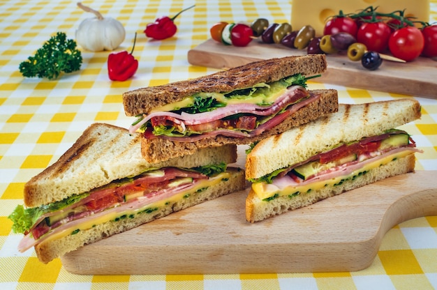 Sanduíche club com salame de presunto, queijo bovino defumado, alface rúcula Preparação de sanduíche de torrada