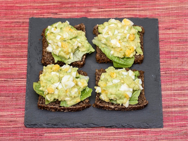 Sanduíche com abacate e ovo escalfado conceito de café da manhã saudável fechar