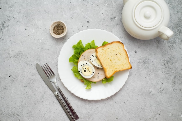 Sanduíche com carne de peru verde e ovo em um fundo cinza Comida saudável