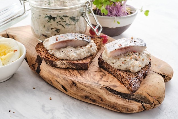 Sanduíche com filé de arenque picado com maçã, cebola e ovo.