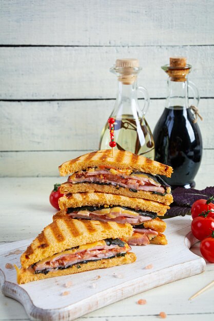 Foto sanduíche com presunto, tomate e queijo. sanduíche grelhado