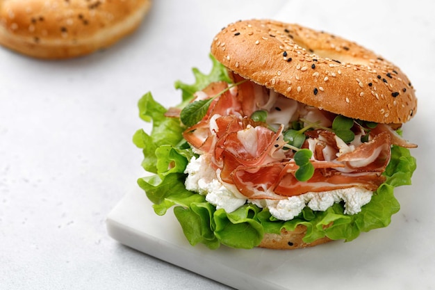 Sanduíche com queijo creme de presunto e bagel de microgreens com alface de presunto no café da manhã