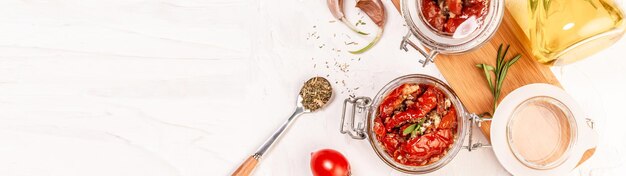 Sanduíche com queijo de cabra, tomate seco e alho, orégano, azeite em uma mesa de luz. espaço para texto. vista do topo. Formato de banner longo.