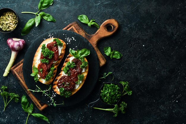 Sanduíche com queijo de tomate seco e manjericão Bruschetta Vista superior sobre um fundo de pedra