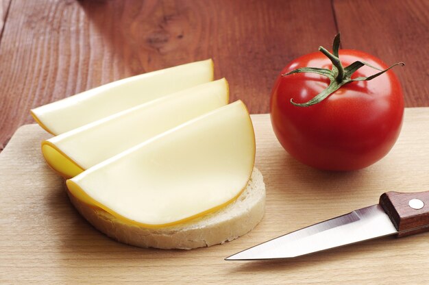 Sanduíche com queijo e tomate na mesa de madeira