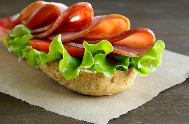 Sanduíche com salame, presunto e salada.