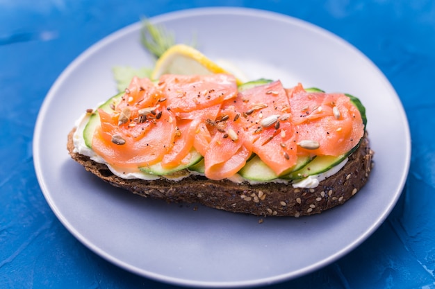 Sanduíche com salmão defumado e pepino. Conceito de nutrição saudável.