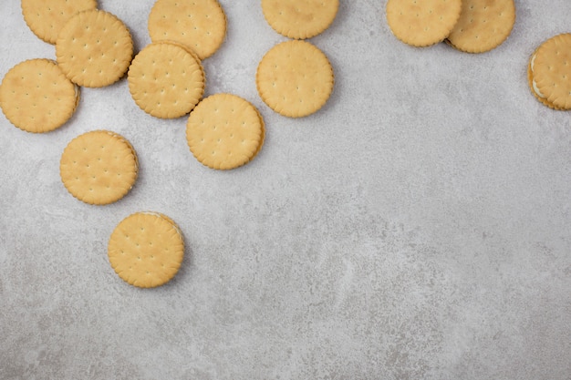 Foto sanduíche de biscoitos duplos com recheio de creme branco sobre uma superfície de concreto cinza claro