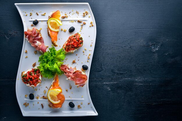 Sanduíche de Bruschetta com salmão e hamoon Em um fundo de madeira Vista superior Espaço livre