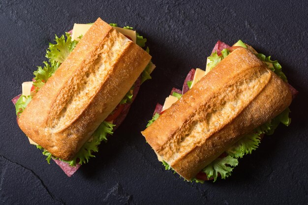 Sanduíche de ciabatta com alface, salame, queijo, abacate e tomate