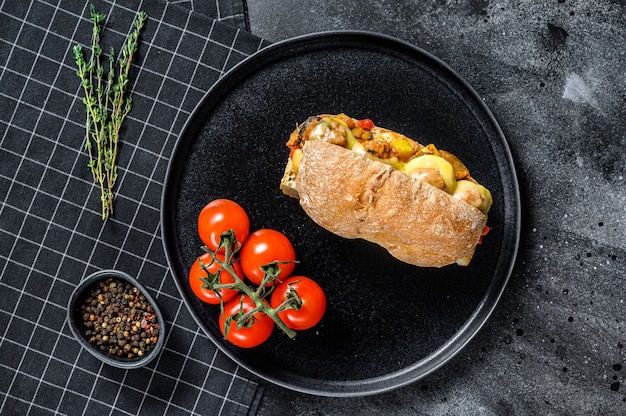 Sanduíche de ciabatta com almôndegas, queijo e molho de tomate. superfície preta. vista do topo