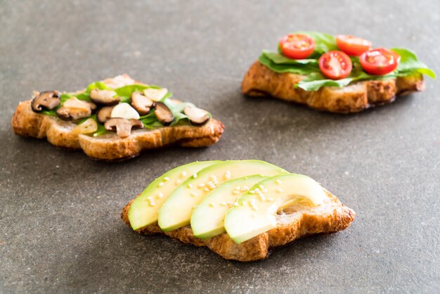 sanduíche de croissant com abacate, tomate e cogumelo