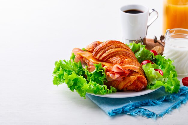 Sanduíche de croissant fresco com presunto, queijo, tomate cereja