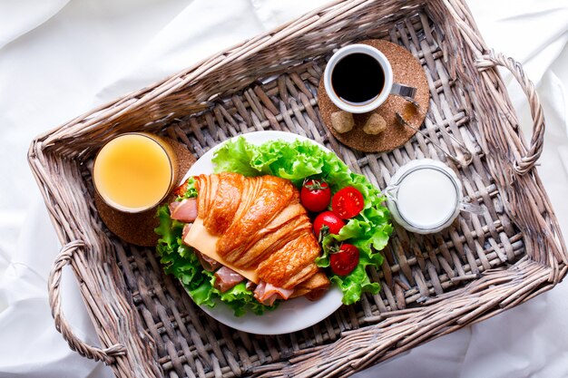 Sanduíche de croissant fresco com presunto, queijo, tomate cereja