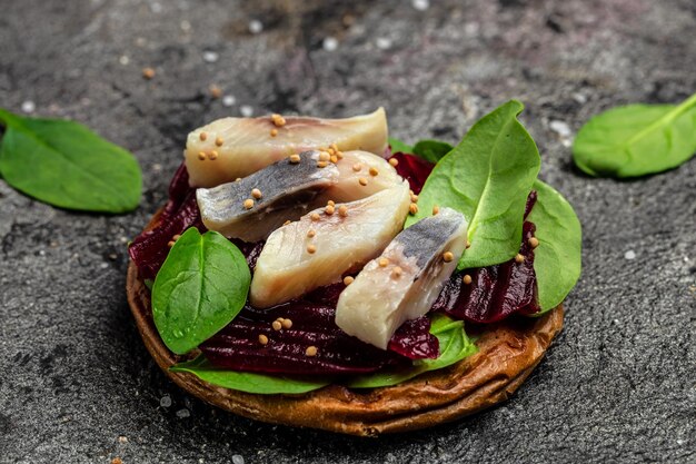 Sanduíche de filé de arenque com fatias de filé de arenque do atlântico em conserva salada de beterraba espinafre verde cebola cozinha escandinava vista superior