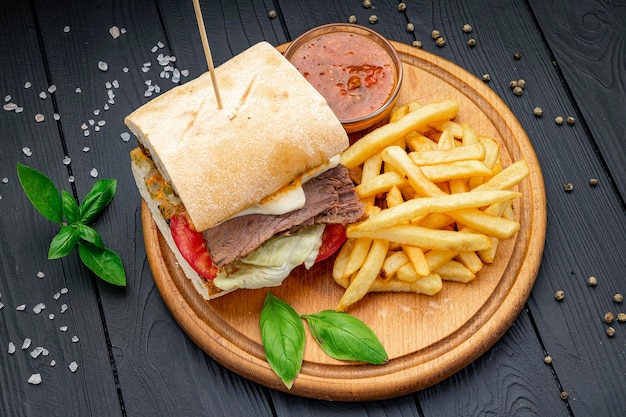 Sanduíche de panini de carne defumada servido com salada e batatas fritas