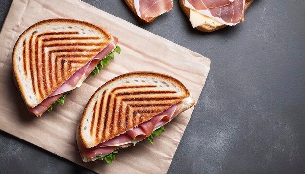 Sanduíche de Panini torrado com presunto e queijo de fundo cinza