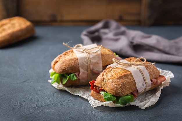 Sanduíche de pão de centeio fresco com presunto, alface e tomate