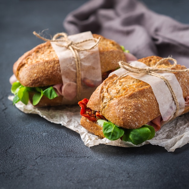 Foto sanduíche de pão de centeio fresco com presunto, alface e tomate