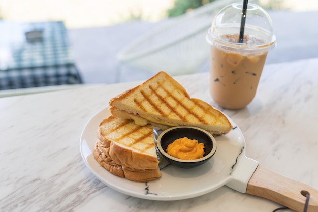 Sanduíche de presunto com molho de creme e café gelado em mármore