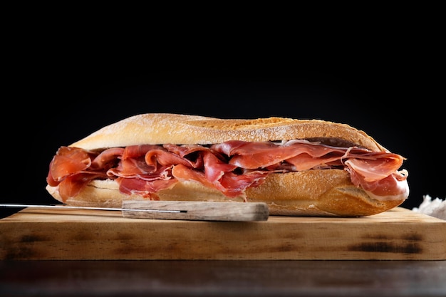 Sanduíche de presunto serrano espanhol na mesa de madeira