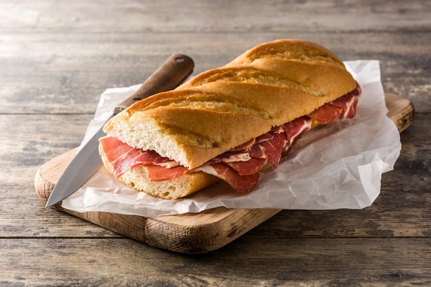 Sanduíche de presunto serrano espanhol na mesa de madeira