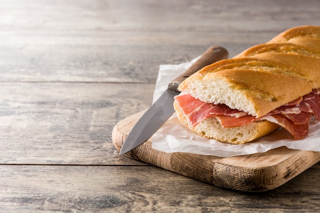 Sanduíche de presunto serrano espanhol no espaço da cópia de mesa de madeira