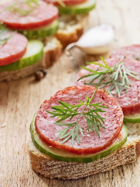 sanduíche de salame na placa de madeira, closeup