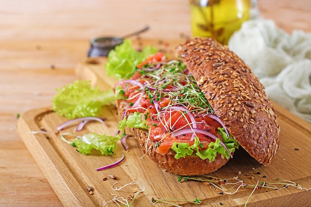 Sanduíche de salmão - smorrebrod com creme de queijo e microgreen na mesa de madeira.