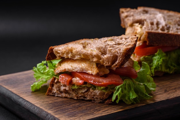 Sanduíche delicioso com tomates e alface crocantes da galinha do brinde