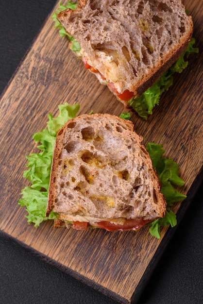 Sanduíche delicioso com tomates e alface crocantes da galinha do brinde