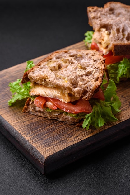 Sanduíche delicioso com tomates e alface crocantes da galinha do brinde